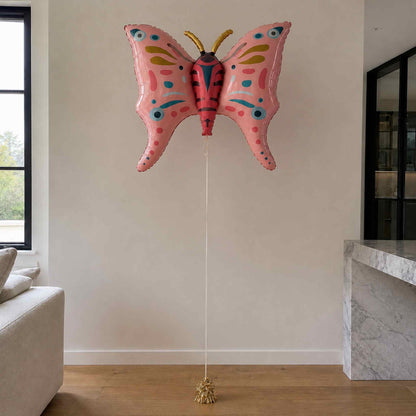 Pink butterfly-shaped balloon in a living room setting