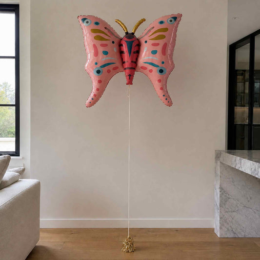Pink butterfly-shaped balloon in a living room setting