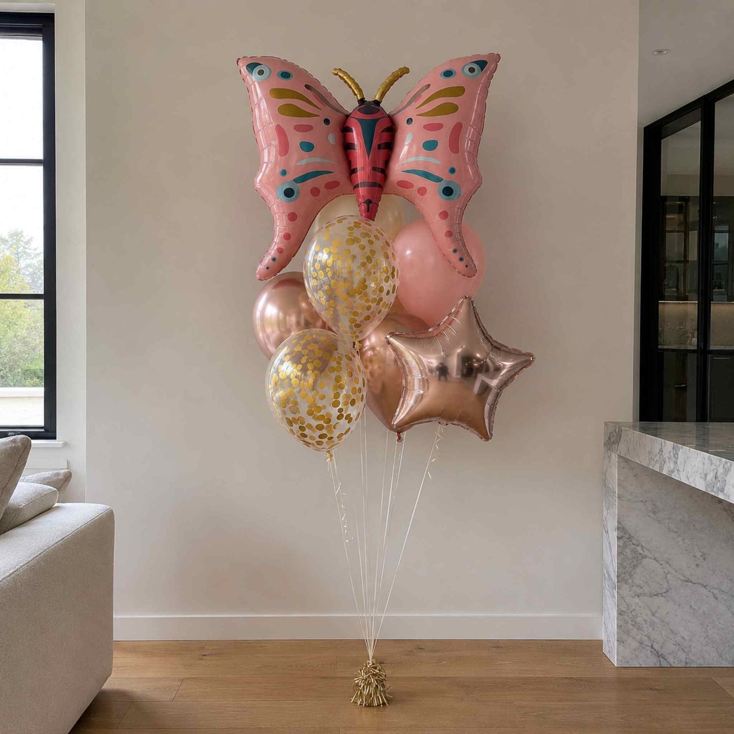 Butterfly-shaped balloon with other balloons in a living room setting