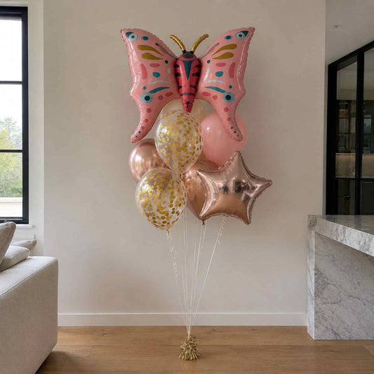 Butterfly-shaped balloon with other balloons in a living room setting