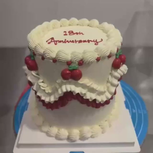 anniversary cake in white and red with cherries, fancy waves 