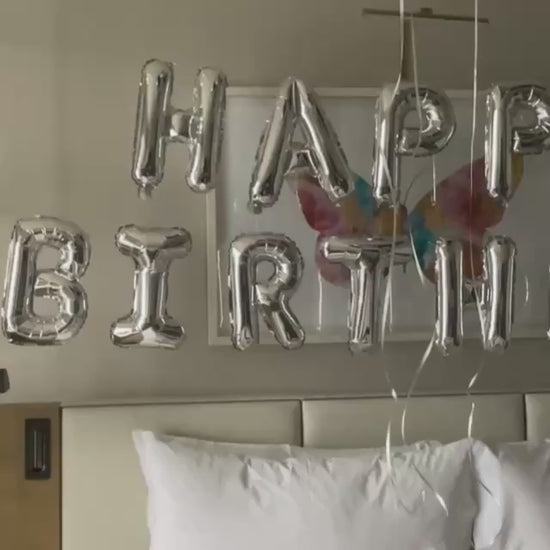happy birthday foil balloon banner silver hotel room
