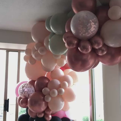 balloon garland setup inside a house, rose gold and soft colours.