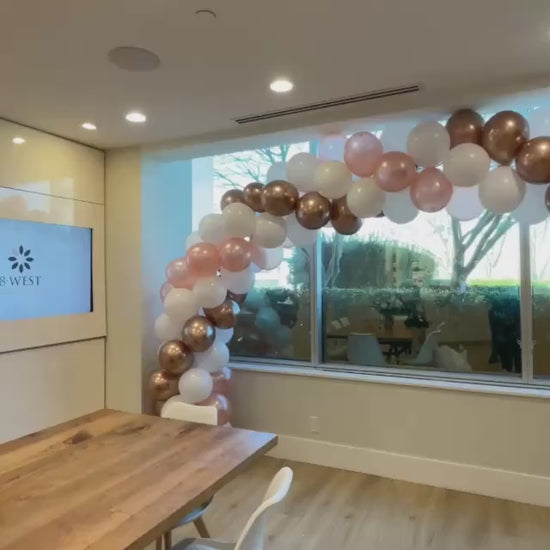 balloon arch skin clinic setup gold and white