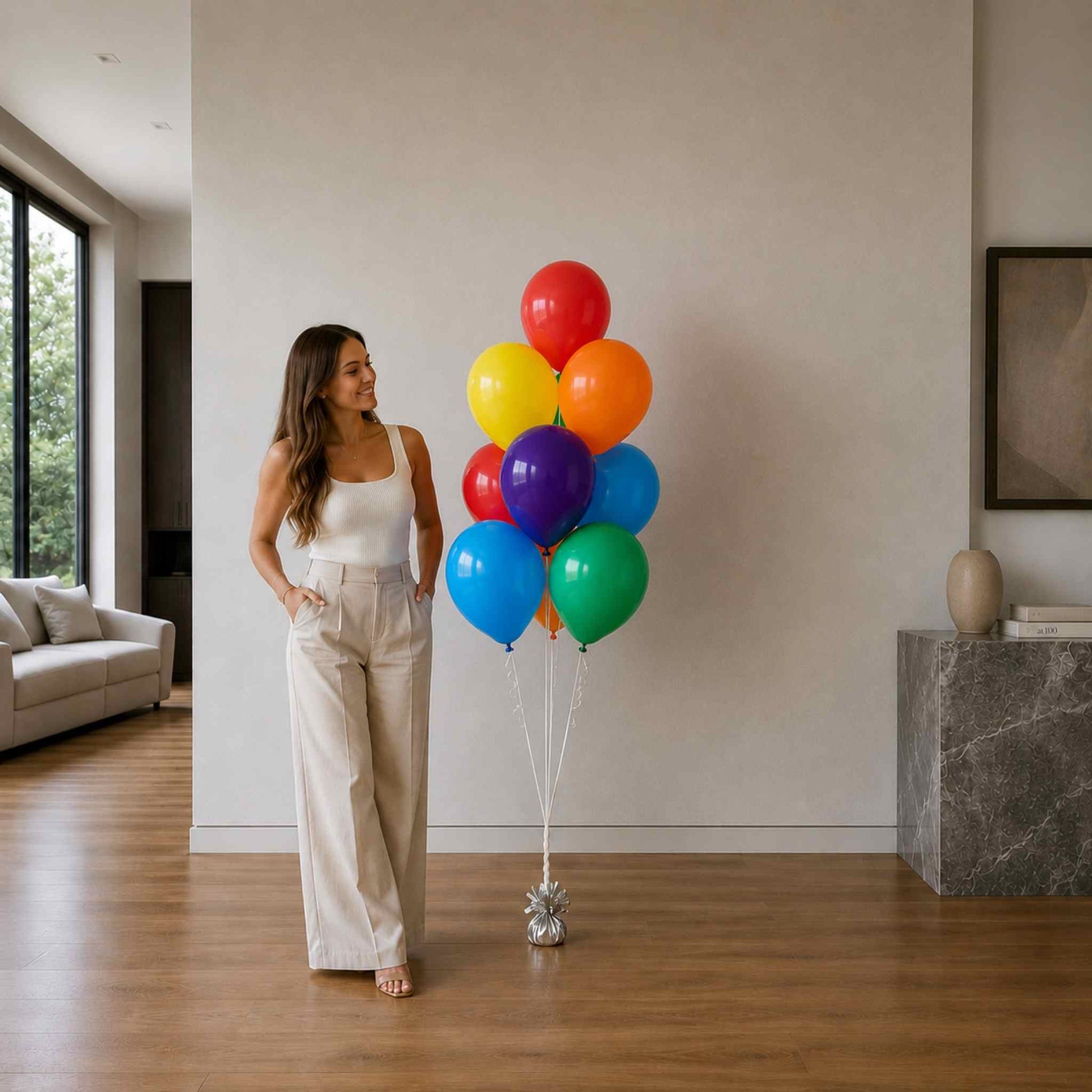 Woman holding a bunch of colorful balloons in a modern living room.