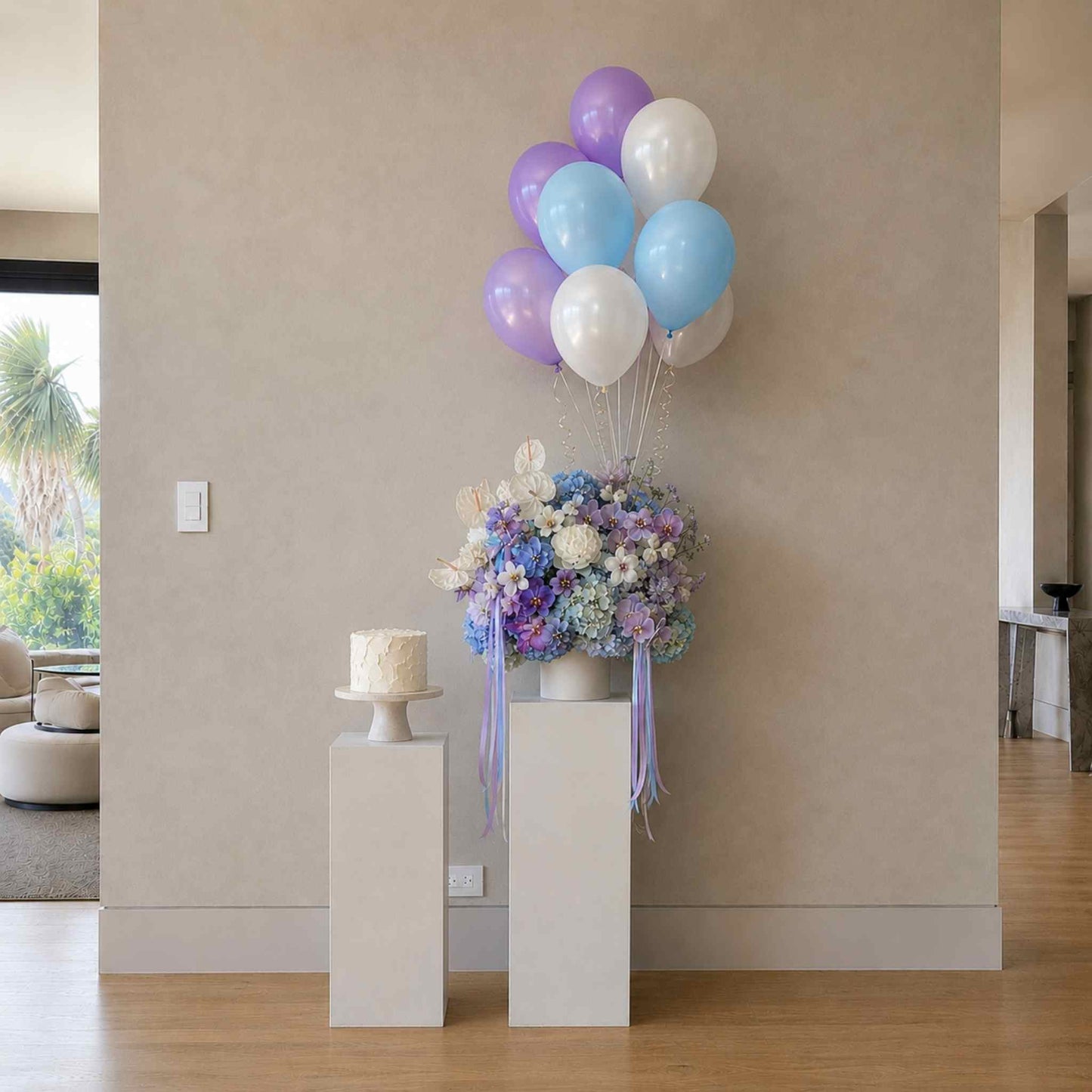 Decorative setup with balloons, flowers, and a cake in a room.