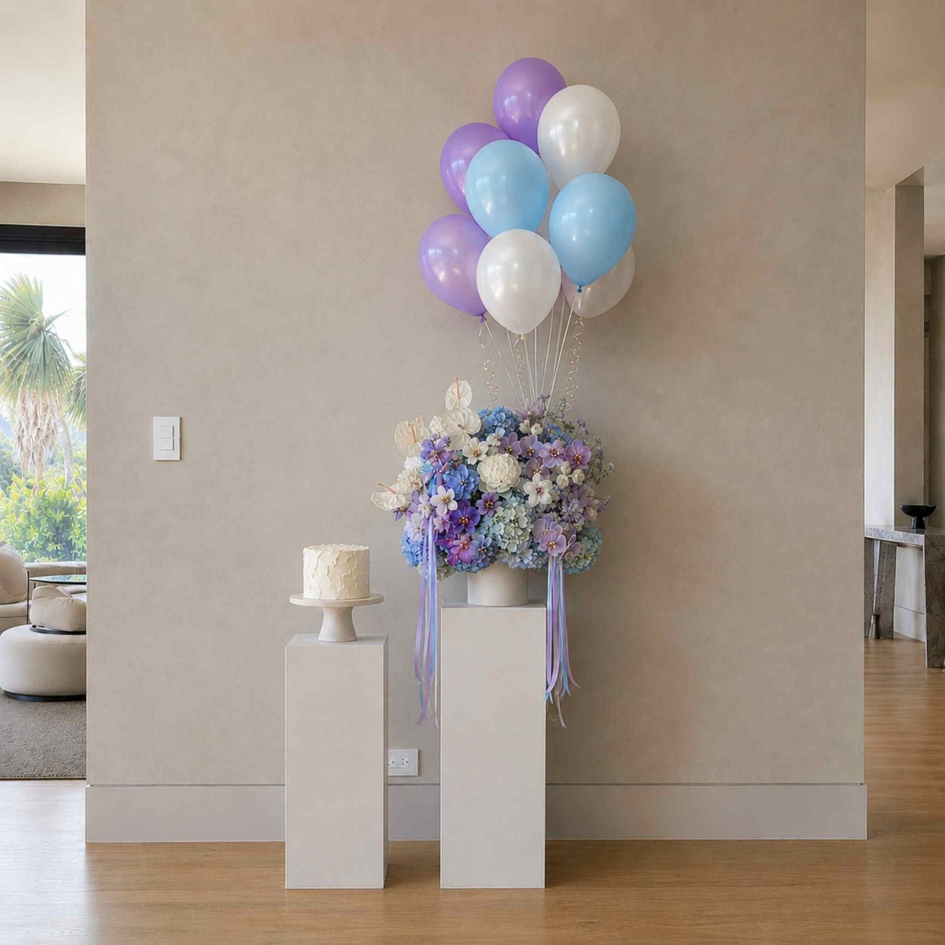 Decorative setup with balloons, flowers, and a cake in a room.