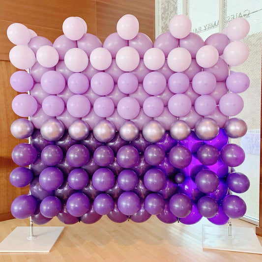 Balloon wall with a gradient from light pink to purple on a stand.