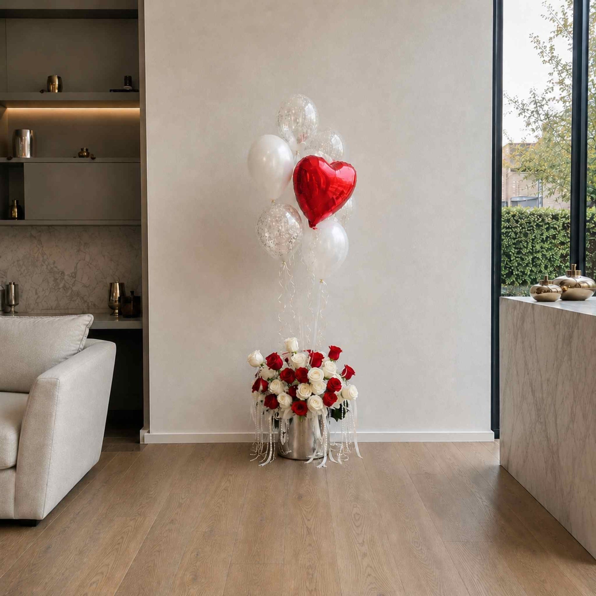 Bouquet of red and white roses with heart-shaped balloon in a modern living room.