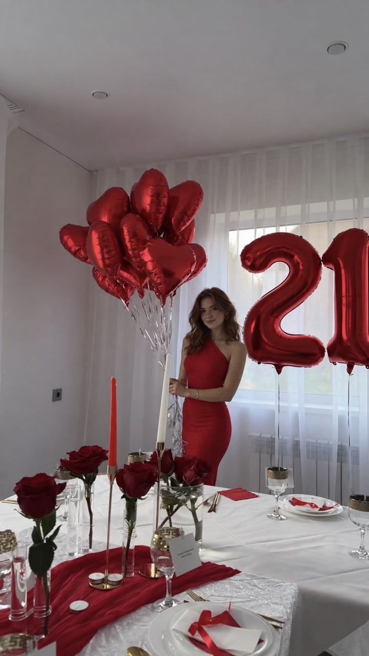 red hearts with number 21 woman posing in house red roses and candles