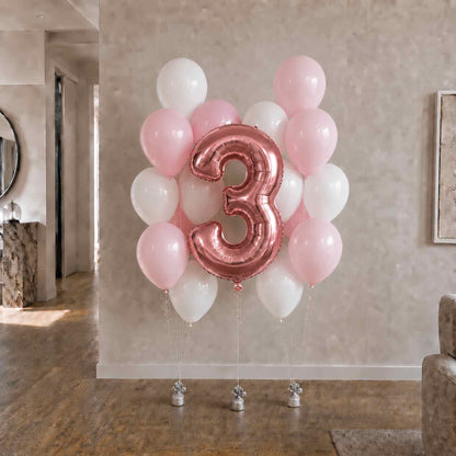 Balloon arrangement with a large number '3' balloon in a room setting.
