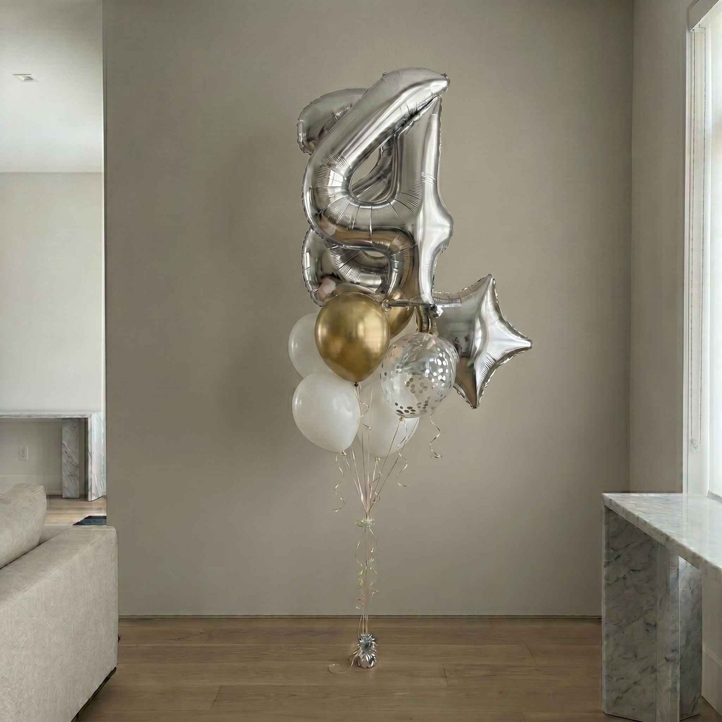 Decorative balloon bouquet with number '4' and star shapes in a living room setting.