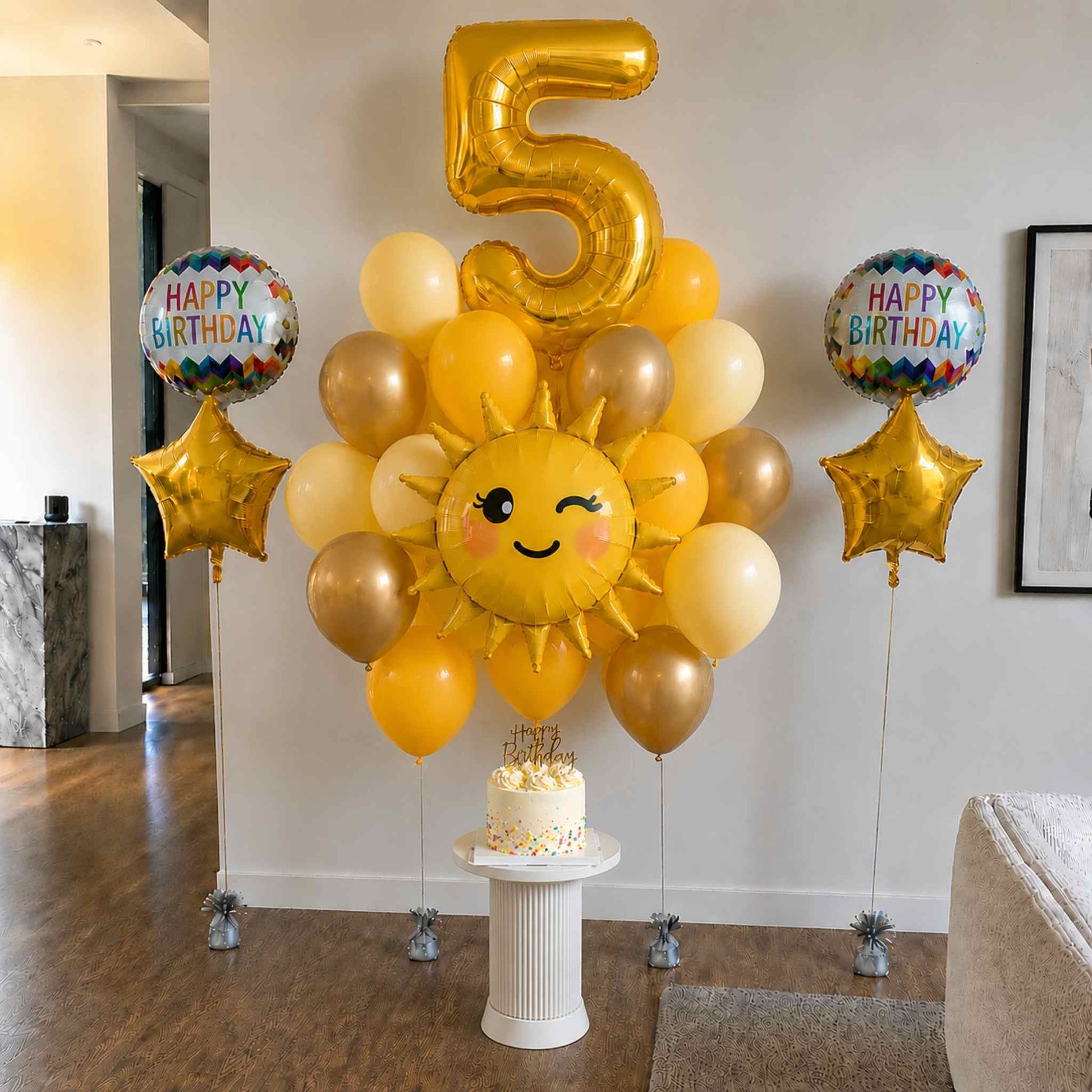 Birthday celebration setup with balloons, a cake, and a 'Happy Birthday' sign in a room.