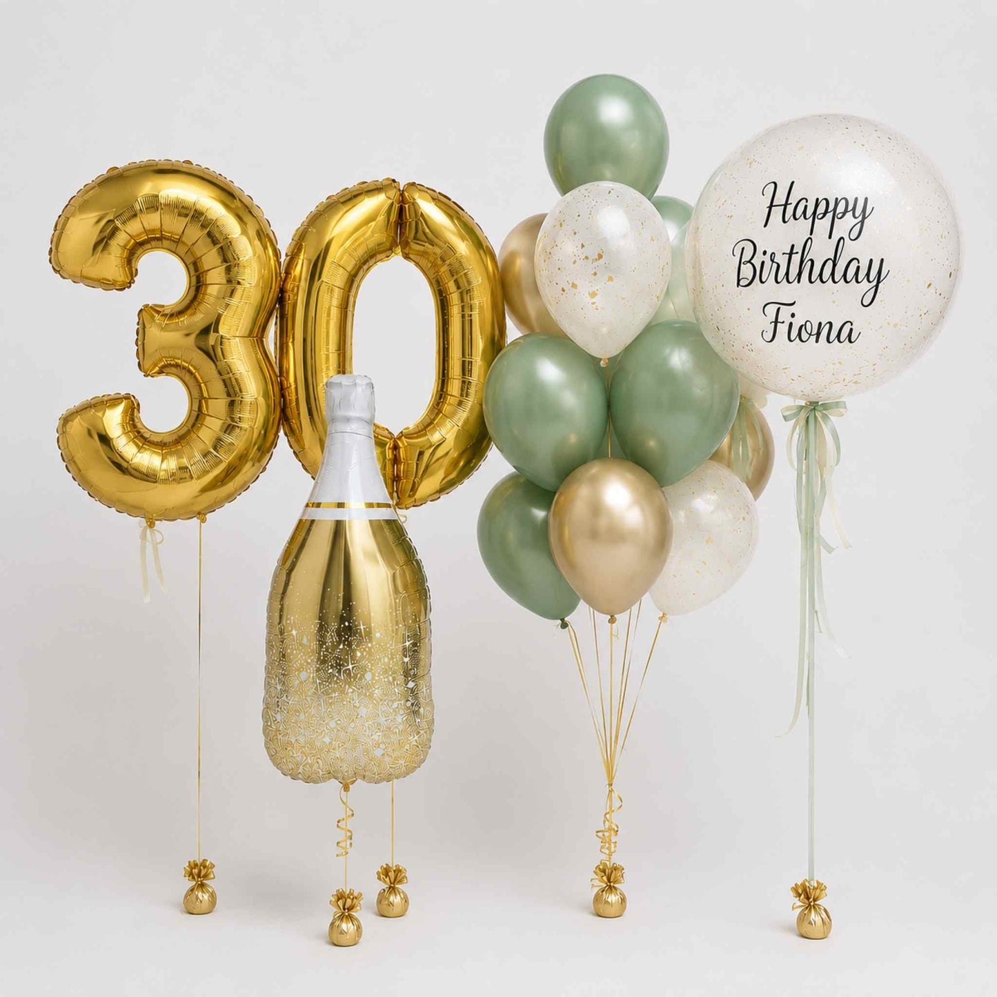 A birthday balloon set featuring metallic gold foil balloons spelling '30' and 'Happy Birthday Fiona', a champagne-shaped gold balloon with glitter, and a cluster of sage green, white, and gold latex balloons on a light gray background.