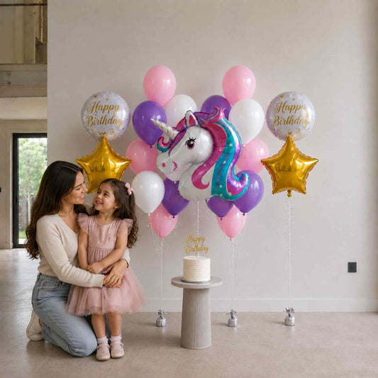 Woman and child with a unicorn balloon and birthday cake in a room.