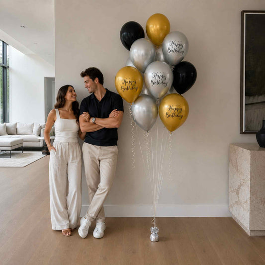 Couple standing in a modern living room with 'Happy Birthday' balloons.