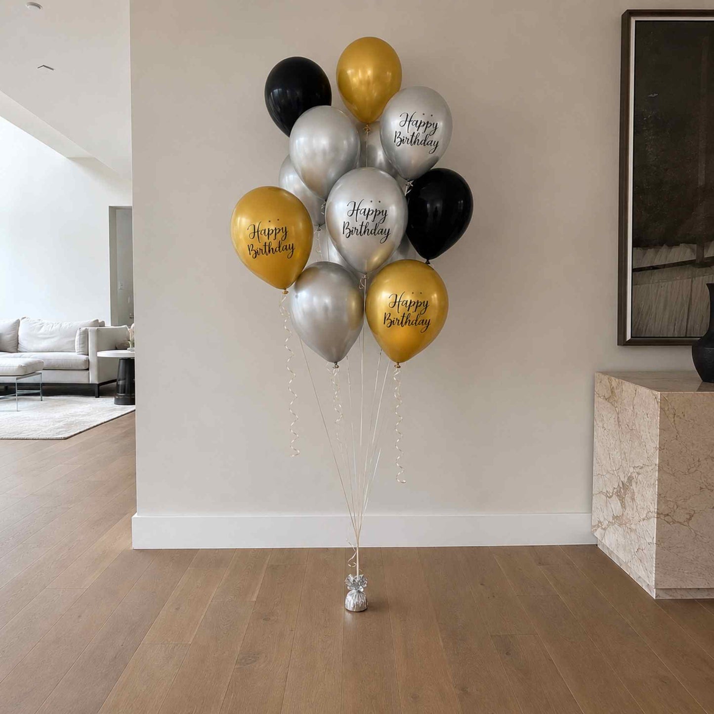 Bunch of balloons with 'Happy Birthday' text in a living room setting