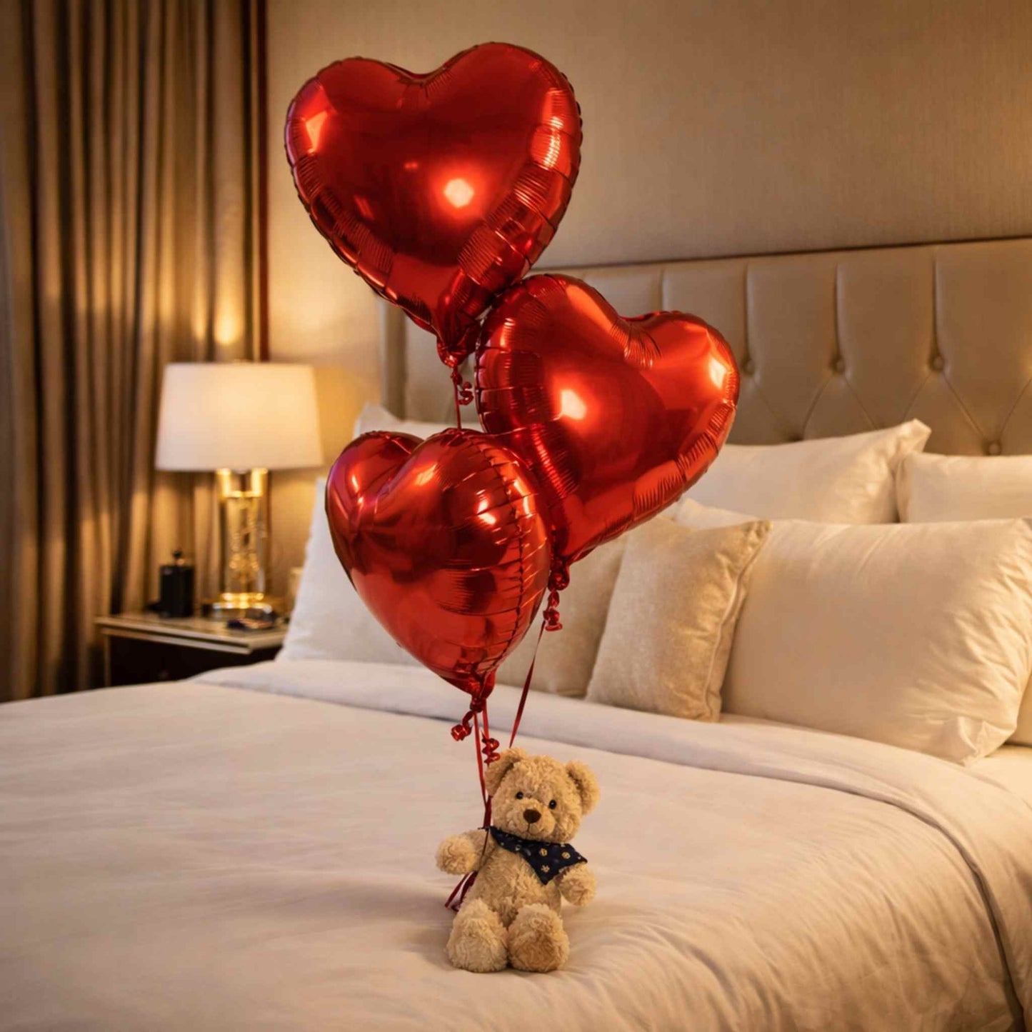 Red heart-shaped balloons with a teddy bear on a bed in a bedroom setting