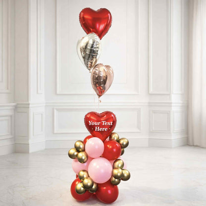 Decorative balloon arrangement with heart-shaped balloons in a room with white walls and floor.