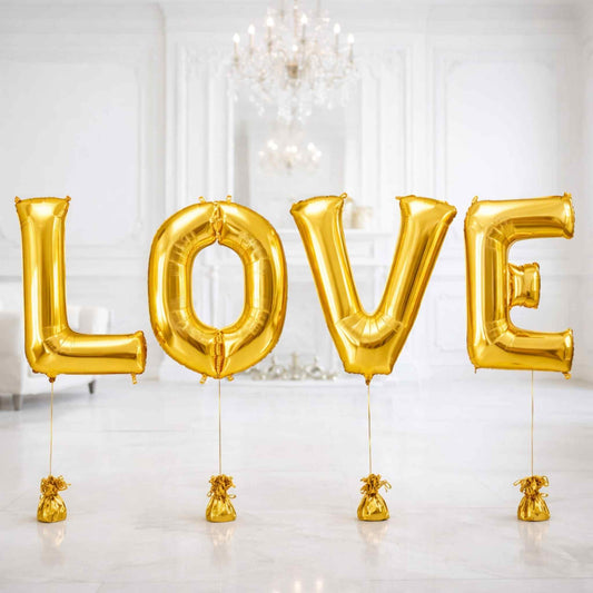 Gold 'LOVE' balloons in a room with chandeliers