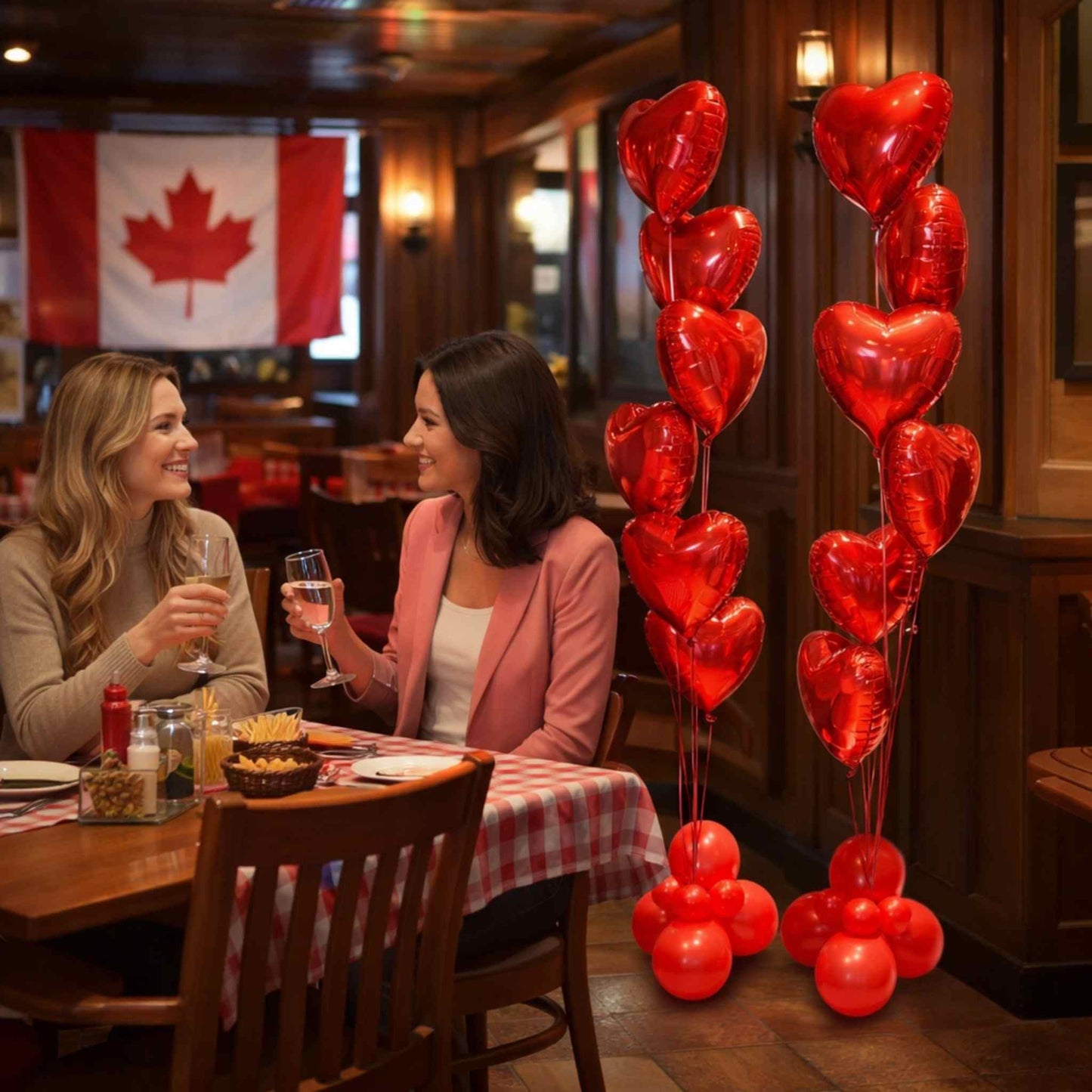 Two women at a restaurant table with heart-shaped balloons and a Canadian flag in the background.