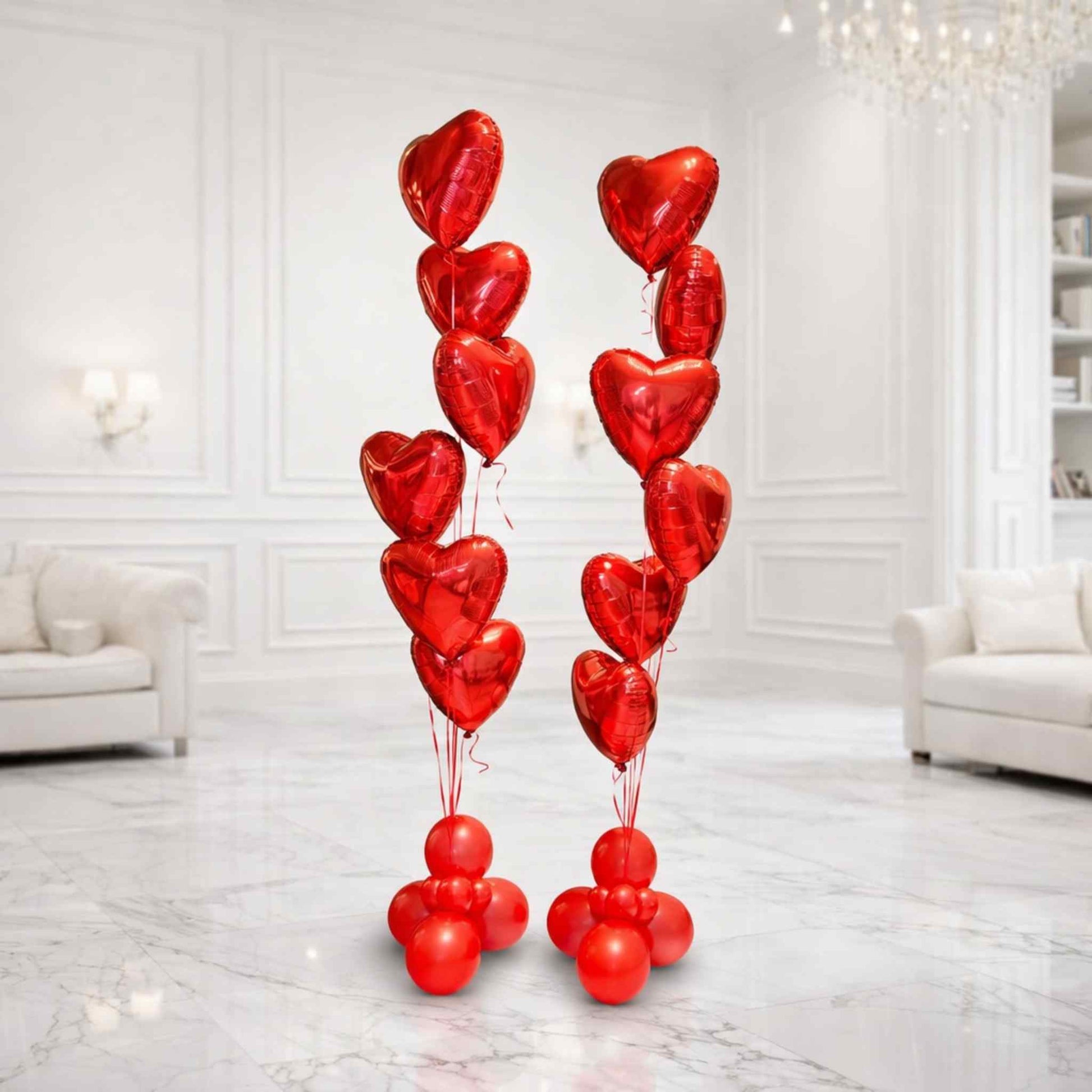 Red heart-shaped balloons arranged in a decorative display in a white room.