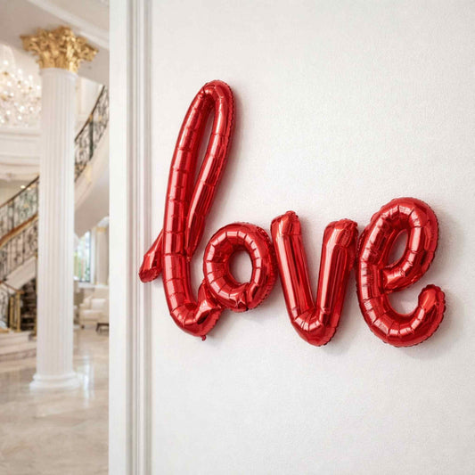 Red 'LOVE' balloons on a white wall with a staircase in the background