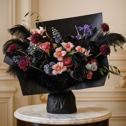 Bouquet of flowers with black paper wrap on a marble surface