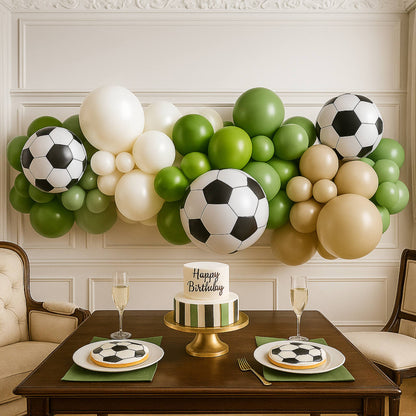 Birthday table setting with soccer-themed decor, including balloons and cake.