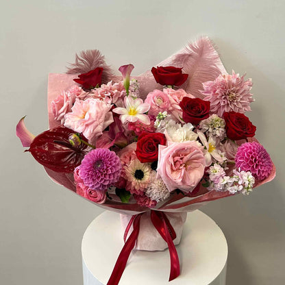 Bouquet of flowers with red, pink, and white colors on a light gray background