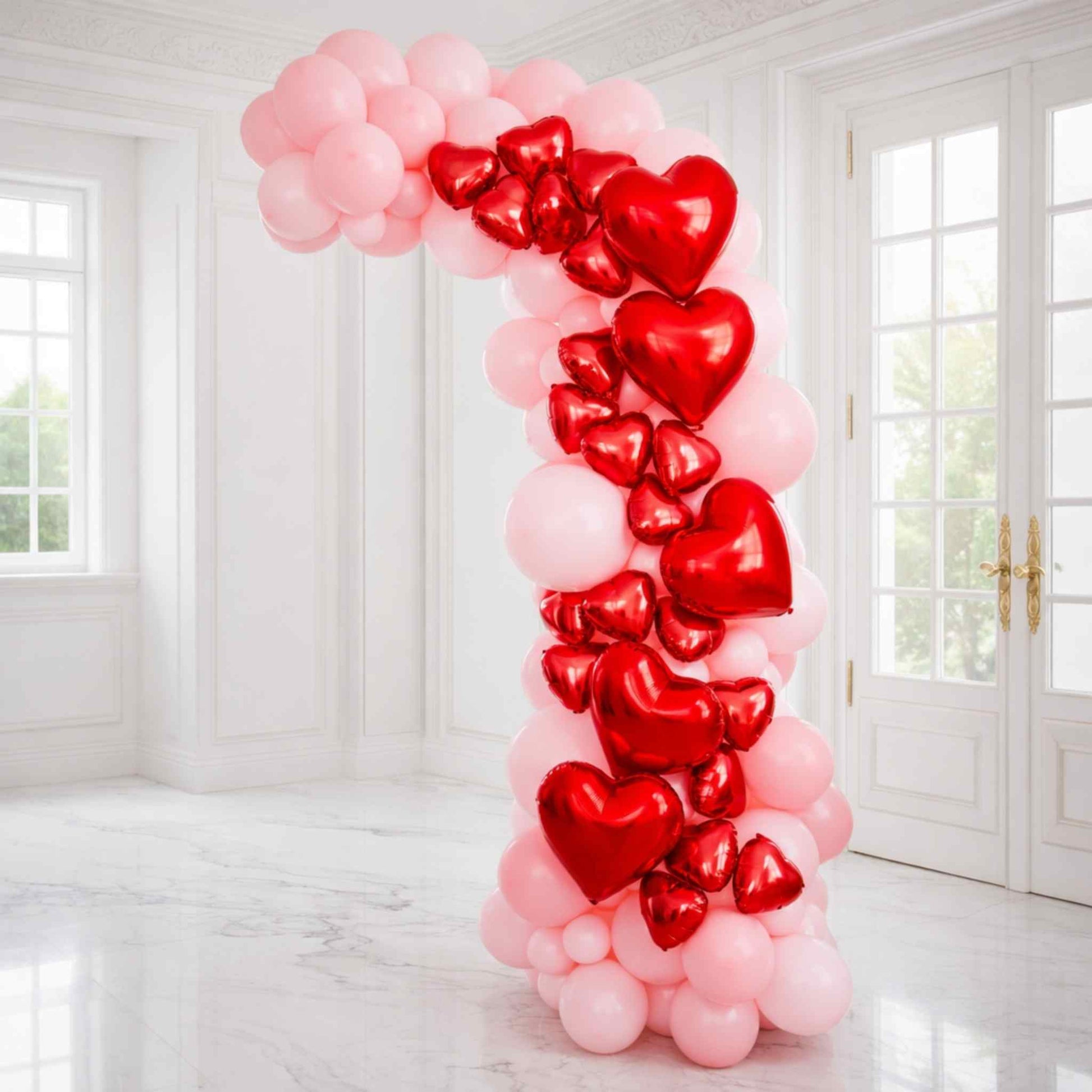 Heart-shaped balloons arranged in a decorative archway in a bright room.