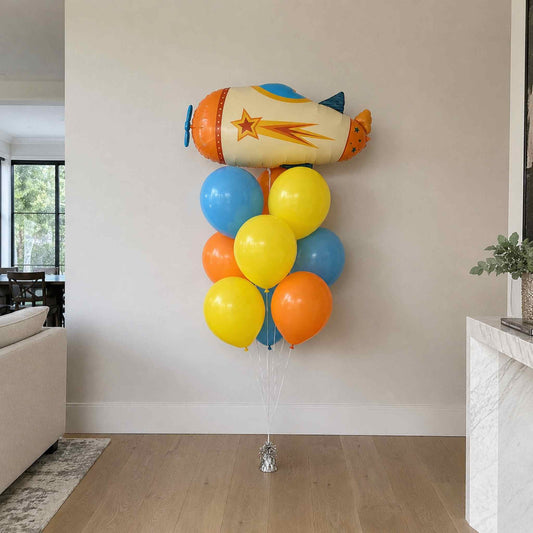 Colorful balloon bouquet shaped like a rocket in a living room setting