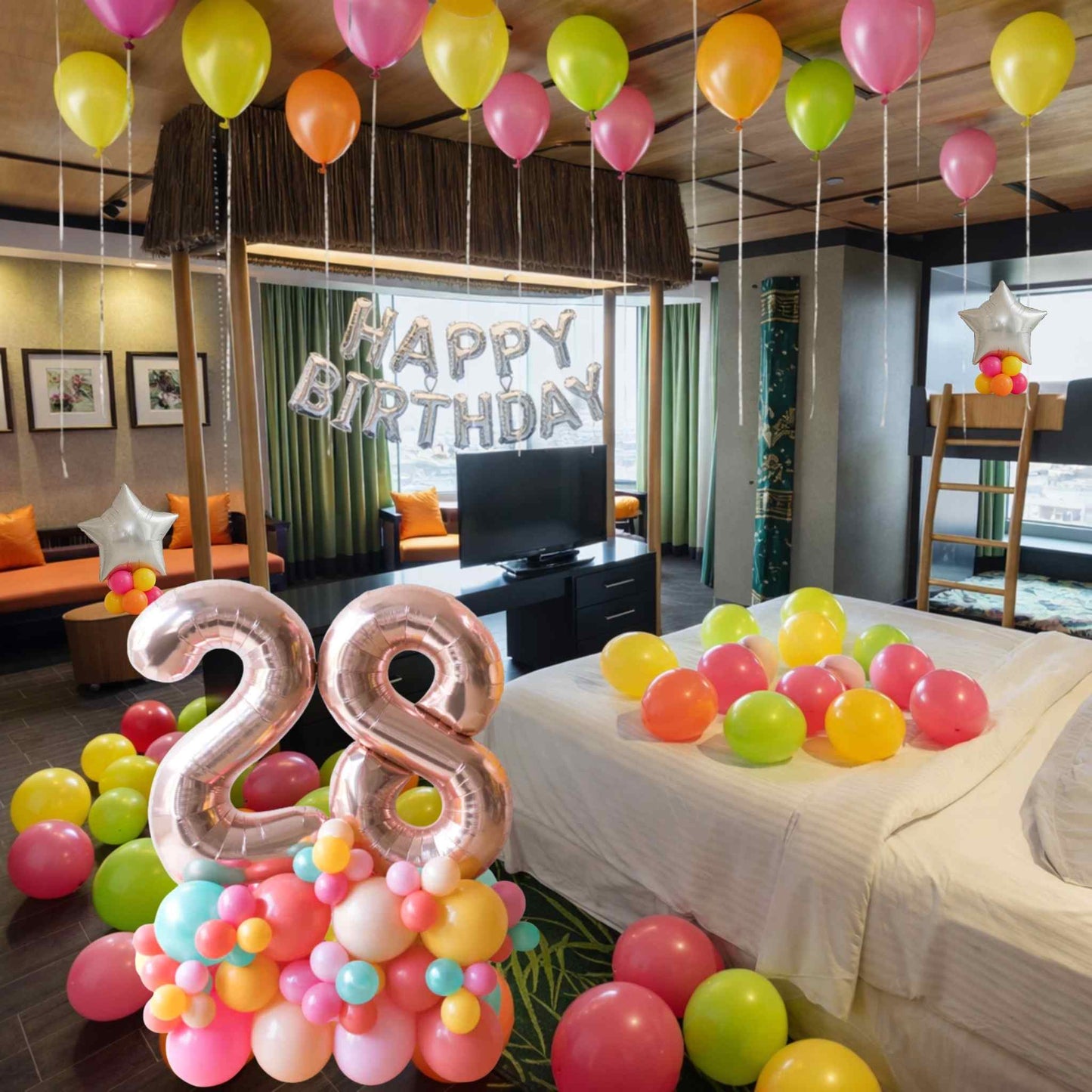 Birthday room decoration with balloons and 'Happy Birthday' banner in a hotel room.