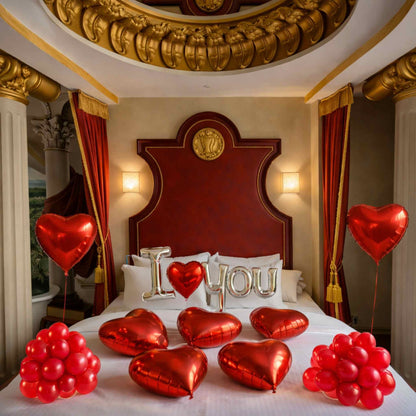 Decorative setup with heart-shaped balloons and 'I LOVE YOU' pillows in a luxurious bedroom.