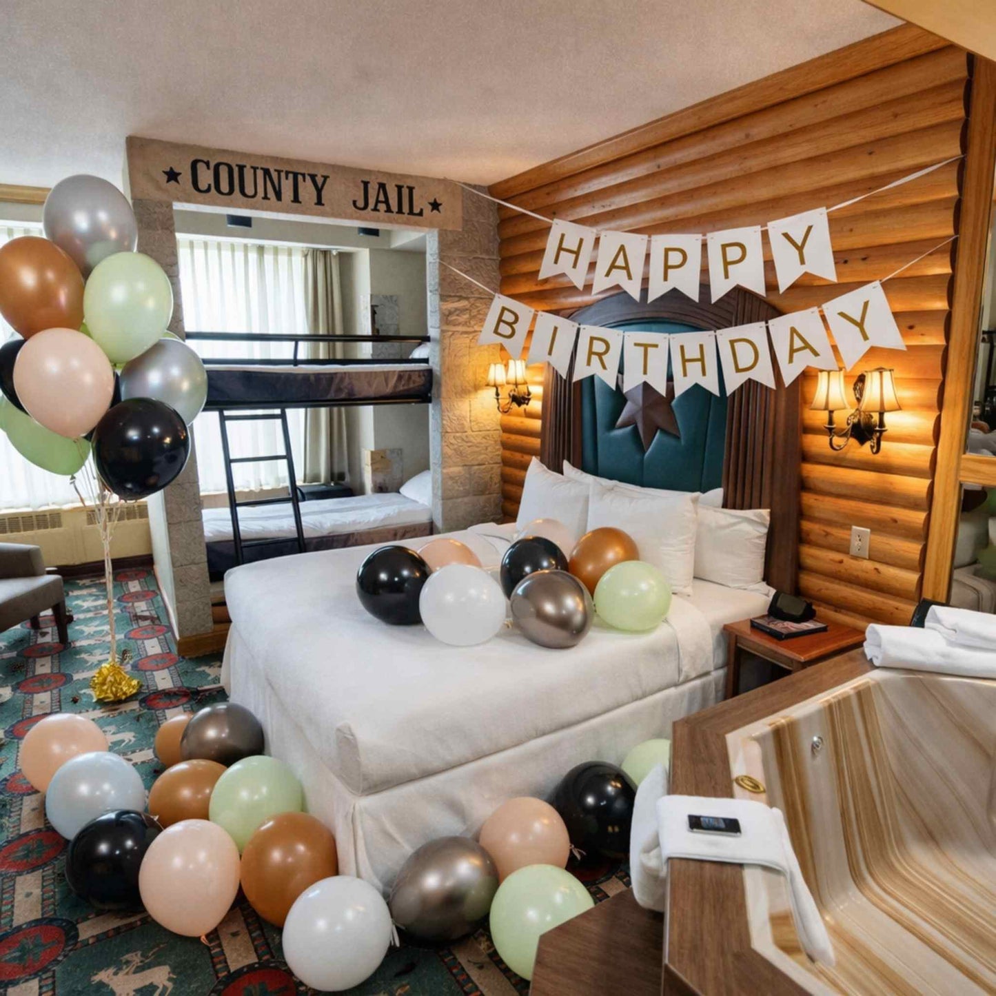 Birthday celebration in a log cabin with balloons and a 'Happy Birthday' banner.