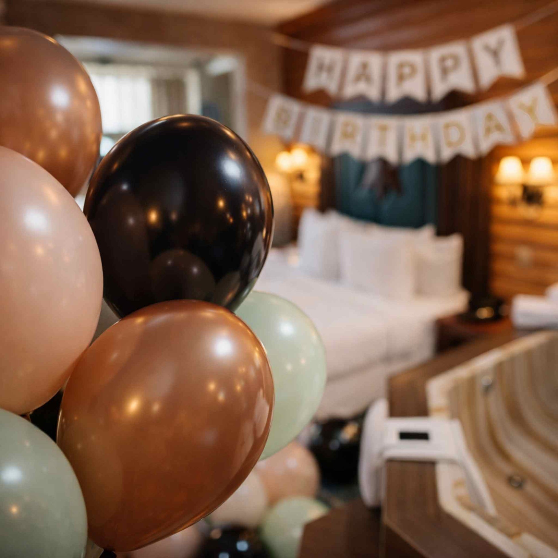 Decorative balloons with a 'Happy Birthday' banner in a room setting.