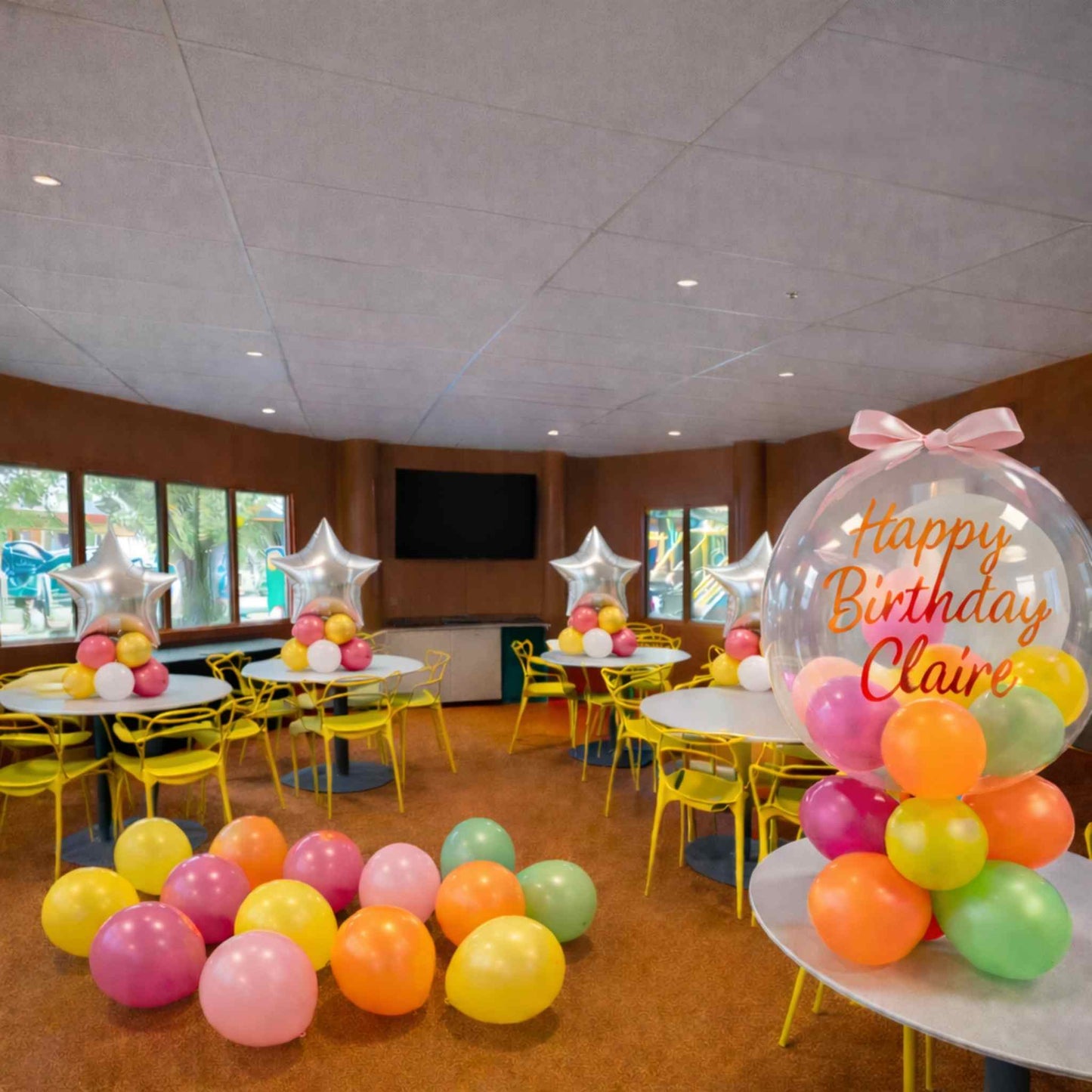Children's birthday party room with colorful balloons and decorations.