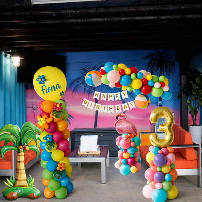 Colorful balloon arch with 'Happy Birthday' banner and number '3' at a birthday party setup.