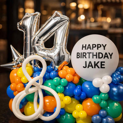 Colorful balloon arrangement with number 14 and 'Happy Birthday Jake' text on a blurred background