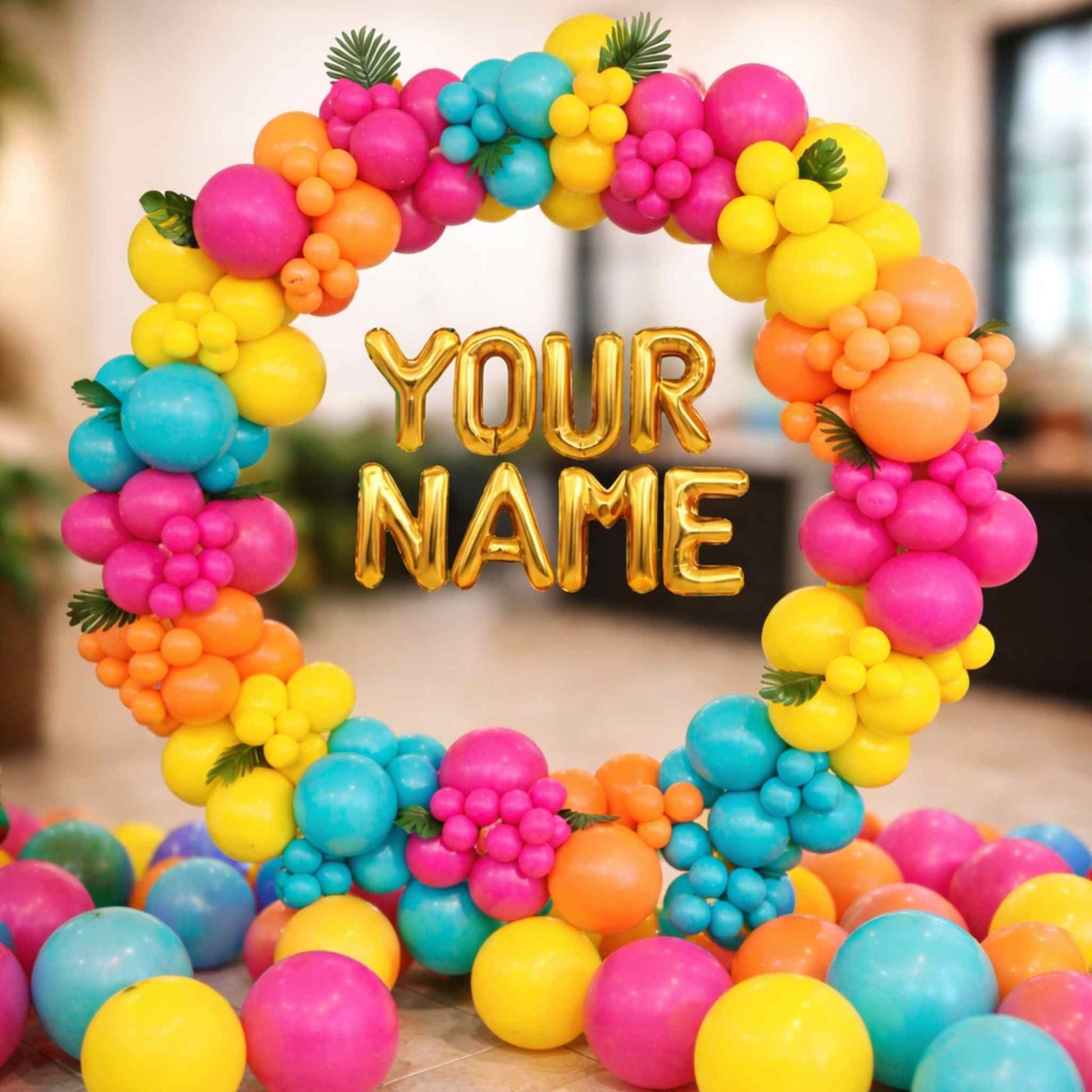 Colorful balloon arch with 'YOUR NAME' text in a blurred indoor setting
