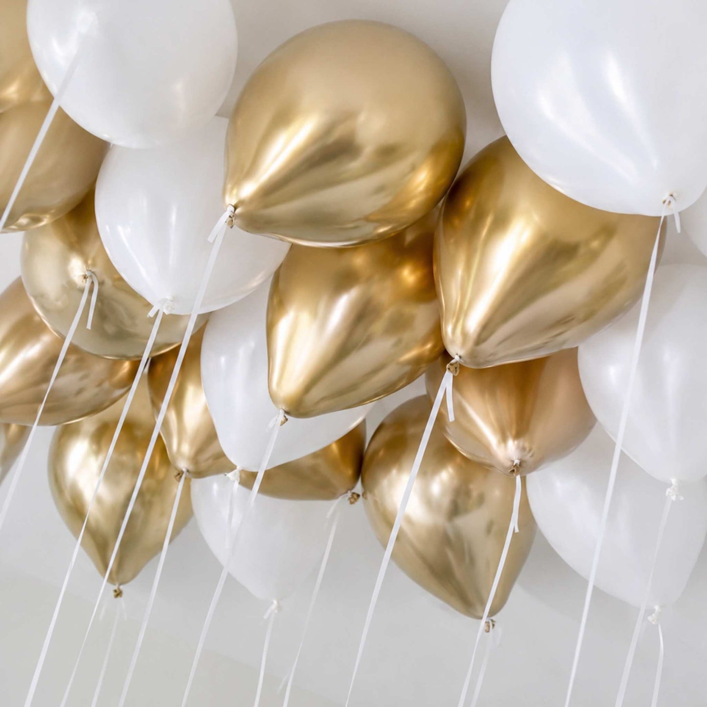 Gold and white balloons against a white background