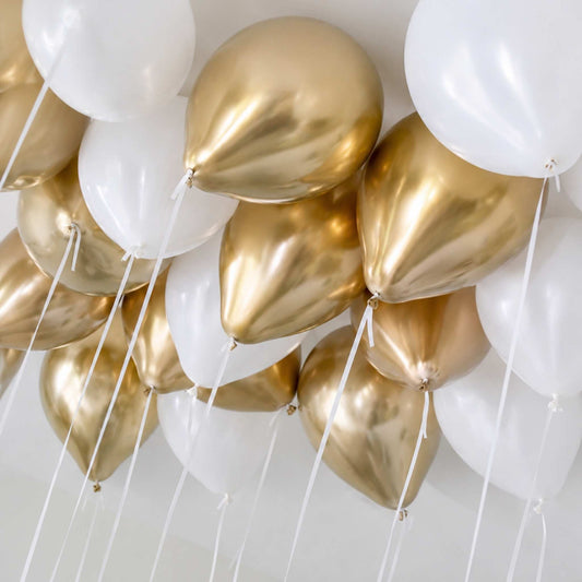 Gold and white balloons against a white background