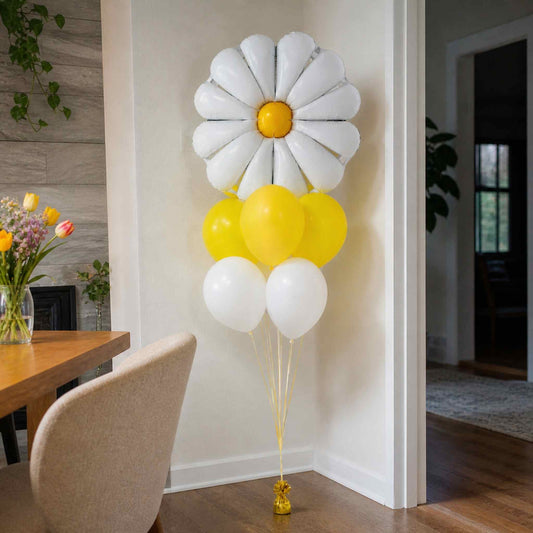 Decorative balloon arrangement shaped like a daisy with yellow and white balloons in a room.