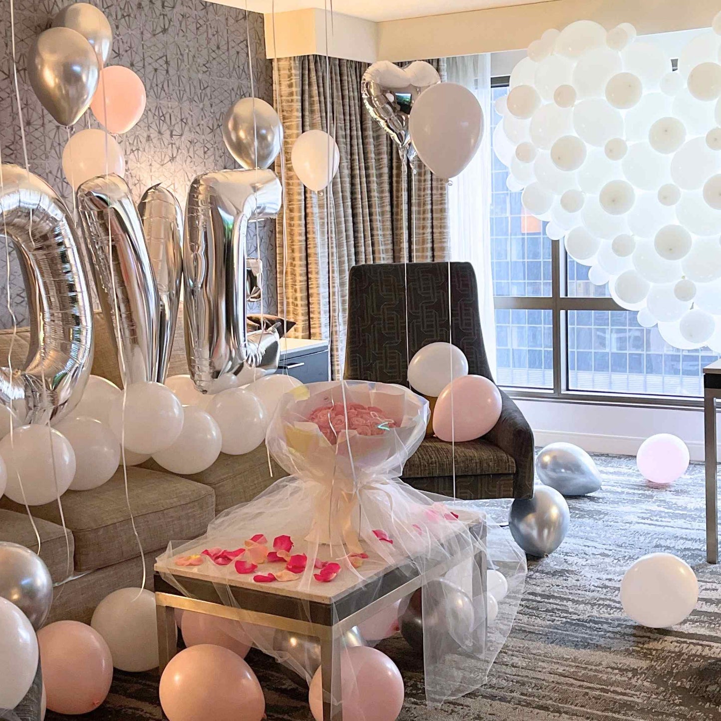 Decorative room with balloons and a small table with flowers.